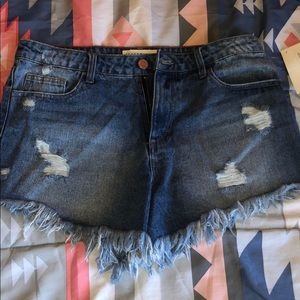 Large, distressed fringed blue jean shorts